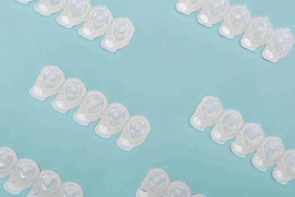 top view of contact lenses in containers arranged on blue background - Photo, Image