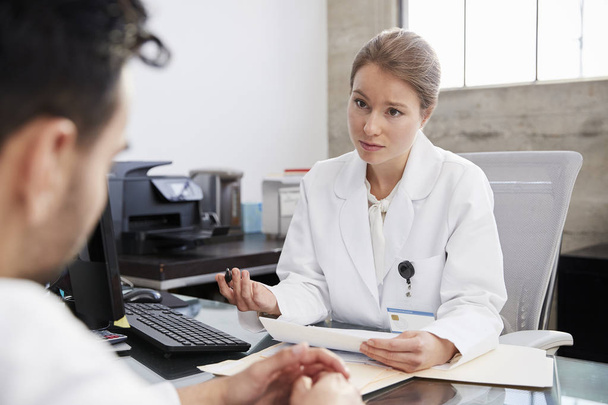 Concerned female doctor in consultation with male patient - Foto, Imagen