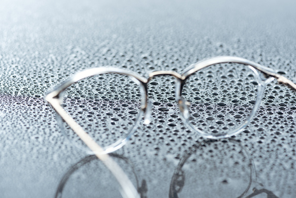 vue rapprochée des lunettes et des gouttes d'eau sur fond gris
 - Photo, image