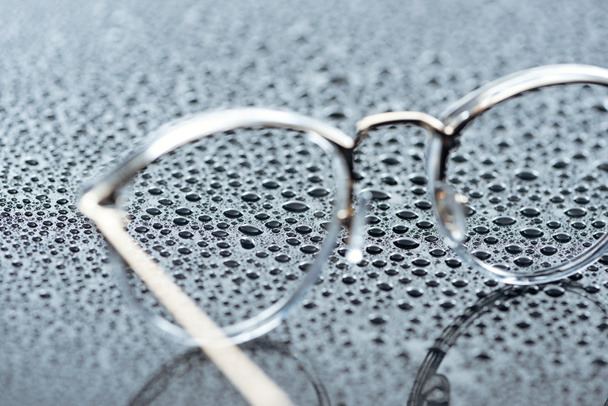 pohled na brýle a kapky vody na šedém pozadí na plochu - Fotografie, Obrázek