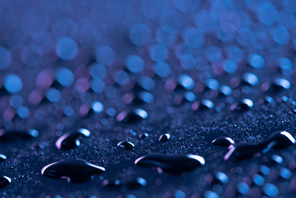 close up view of water drops on blue surface as background - Foto, Imagem