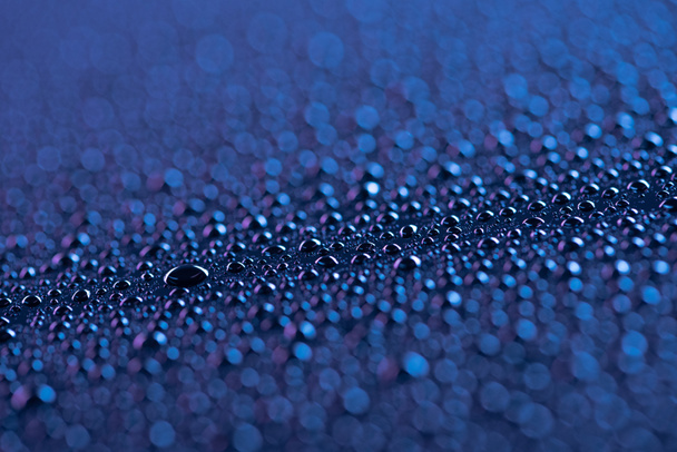 selective focus of water drops on blue surface as background - Foto, immagini