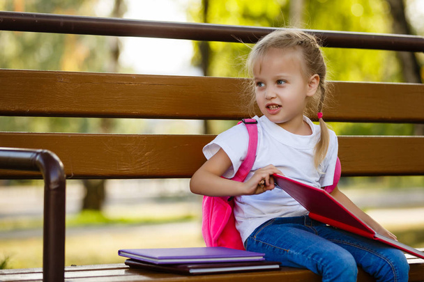 Roztomilá malá školačka pocit velmi nadšeni jít zpátky do školy - Fotografie, Obrázek