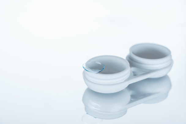 Nahaufnahme von Kontaktlinse und Behälter auf weißem Hintergrund - Foto, Bild