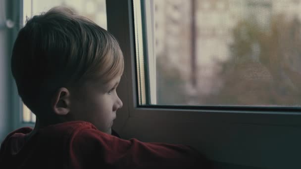 dziecko, smutny i samotny, patrząc przez okno. Dziecko jest w depresji - Materiał filmowy, wideo
