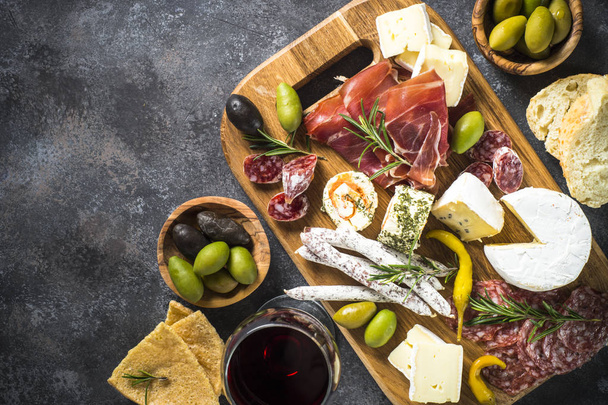 Antipasto bord met gesneden vlees, ham, salami, kaas, olijven een - Foto, afbeelding