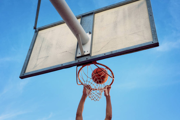 Calle atleta de baloncesto realizando slam dunk en la cancha - Foto, Imagen