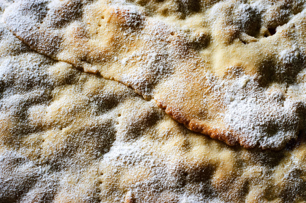 food background the surface of the cake sprinkled with powdered sugar - Photo, Image