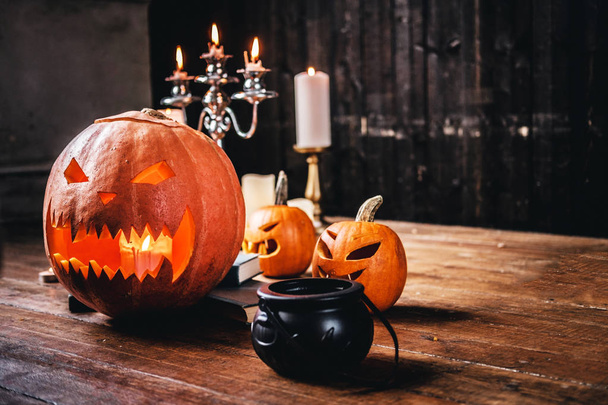 Scary pumpkins and candles on a wooden floor in an old house. - Foto, Bild