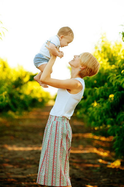 Feliz joven madre jugando con su hijo al aire libre
  - Foto, Imagen