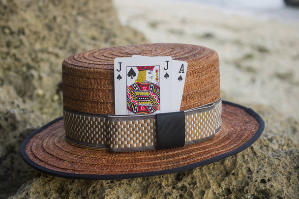 sombrero marrón del navegante con las tarjetas negras del gato en la playa
 - Foto, Imagen