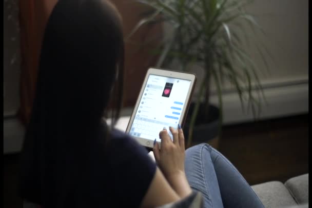 mujer joven usando su tableta para enviar mensajes de texto
 - Metraje, vídeo