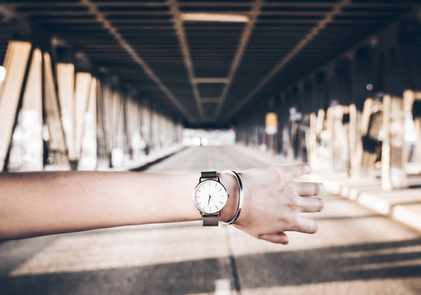 reloj de pulsera y pulsera en el brazo contra la calle de la ciudad
 - Foto, imagen