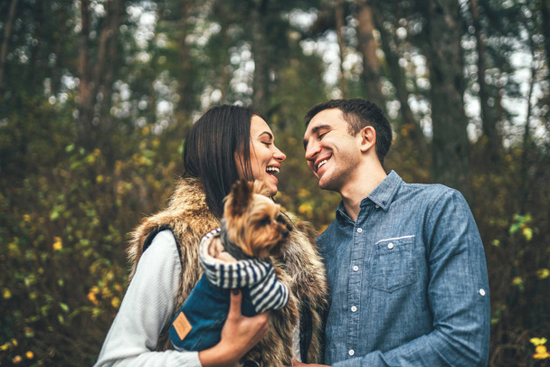 Pretty couple with little yorkshire terrier walking in the forest - Photo, Image