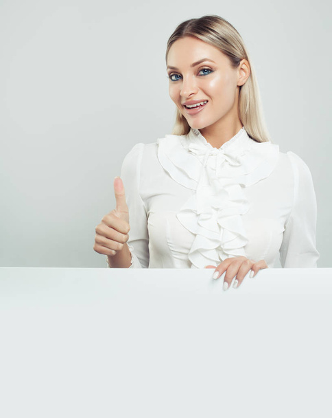 Счастливая бизнес-леди с большим пальцем вверх и белым пустым фоном на доске с копировальным пространством для рекламного маркетинга или производства цемента. Портрет успешной деловой женщины
 - Фото, изображение
