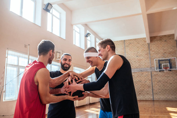 Basketball players holding the ball on the court. - 写真・画像