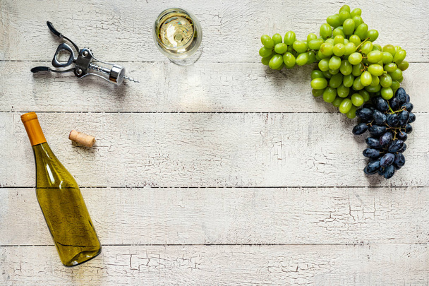 Vinho branco com uvas numa mesa de madeira branca descascada e intemperizada
 - Foto, Imagem