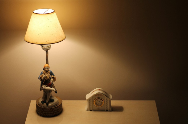 lámpara y reloj en la mesa
 - Foto, Imagen