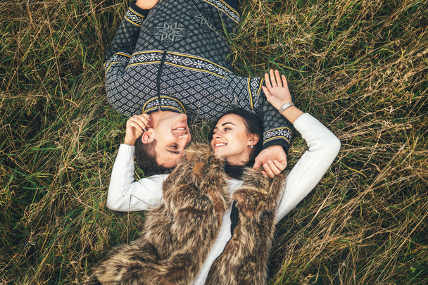 Up view of pretty couple lying in the grass - Zdjęcie, obraz