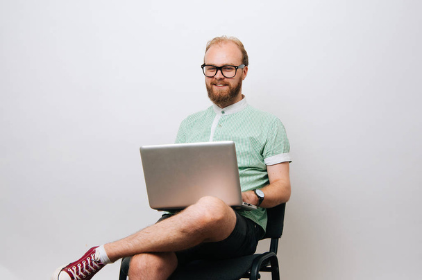 Jeune homme hipster barbu utilisant un ordinateur portable sur fond blanc
 - Photo, image