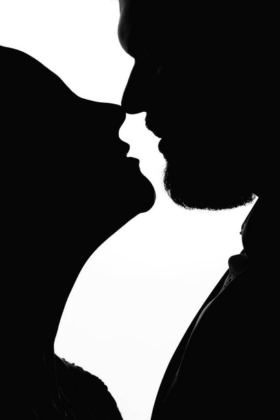 Close-up silhouet van jonggehuwden die elkaar op een witte achtergrond kijken - Foto, afbeelding