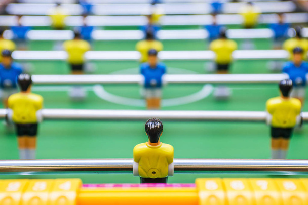 Настольный футбол, футбольный стол с желтыми и синими игроками. Футбольный стол с желтыми и синими игроками
 - Фото, изображение