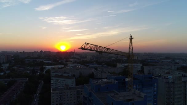 Gebouw kraan tegen de achtergrond van de stad en de zonsondergang - Video