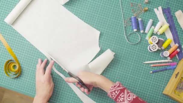 Keski-ikäinen nainen kädet sakset leikkaamalla paperi malli. Käsintehty kangas
. - Materiaali, video