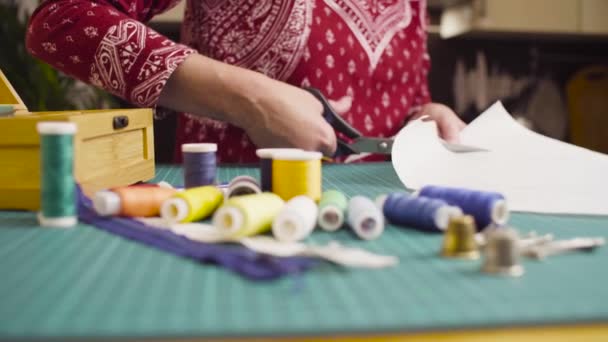 Frauen mittleren Alters greifen zur Schere und schneiden Papiermuster. Handgemachte Kleidung. - Filmmaterial, Video