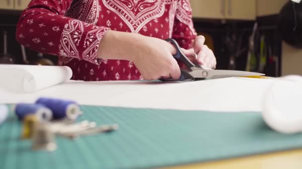 Žena středního věku ruce nůžky řezání papíru vzorem. Ručně vyráběné oblečení. - Záběry, video