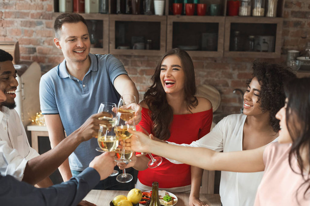Amigos felices animando con copas de vino en casa
 - Foto, Imagen