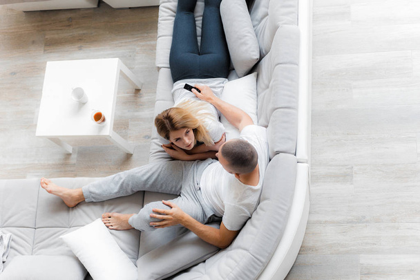 Young couple resting on sofa at home. Family relaxation lifestyle - Foto, imagen