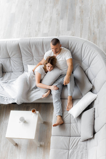 Young couple resting on sofa at home. Family relaxation lifestyle - Foto, immagini