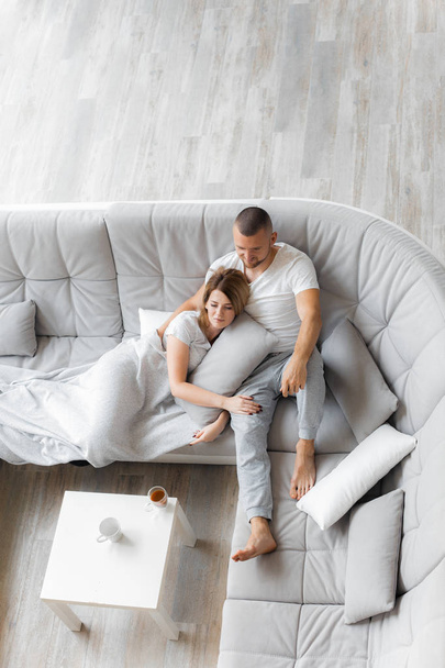 Young couple resting on sofa at home. Family relaxation lifestyle - Foto, Imagem