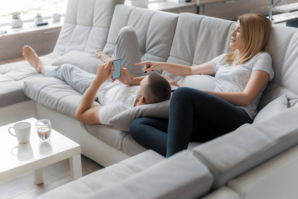 Young couple resting on sofa at home. Family relaxation lifestyle - Foto, immagini
