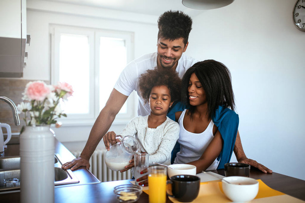 Smiling african american family enjoying having breakfast together at home. - Foto, Imagen
