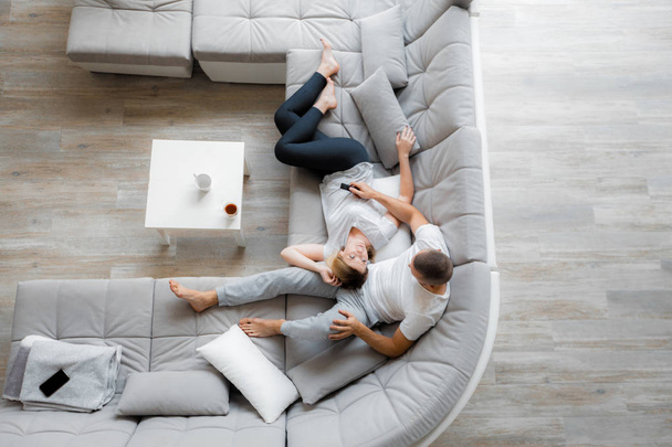 Young couple resting on sofa at home. Family relaxation lifestyle - Valokuva, kuva