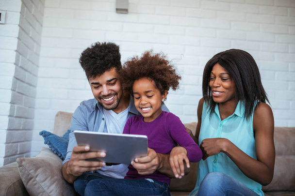 Happy african american family surfing the net on the tablet. - Foto, imagen