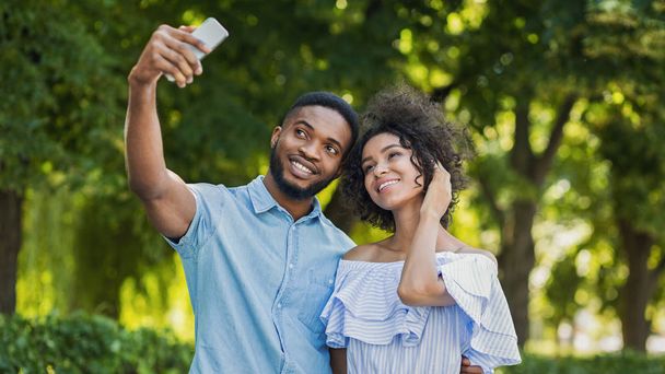 Vidám szép pár pózol együtt, és így selfie a smartphone a szabadban - Fotó, kép