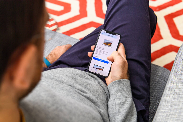 Λονδίνο, Ηνωμένο Βασίλειο - 21 Σεπ, 2018: Ο άνθρωπος χρησιμοποιώντας το νέο Apple iphone Xs με τεράστια Oled αμφιβληστροειδή εμφανίσετε και Α12 βιονικά τσιπ, κοιτάζοντας πέρα από την εφαρμογή app αγορά Macbook Air - Φωτογραφία, εικόνα