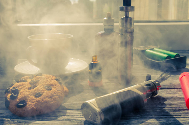 Stillleben mit E-Zigarette und Kaffee auf dem Holzgrund - Foto, Bild
