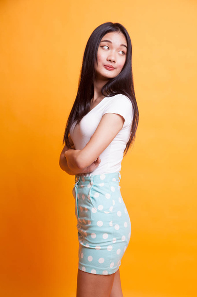 Portrait of beautiful young Asian woman on bright yellow background - 写真・画像