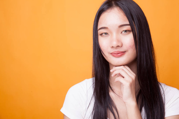 Portrait of beautiful young Asian woman on bright yellow background - Фото, изображение