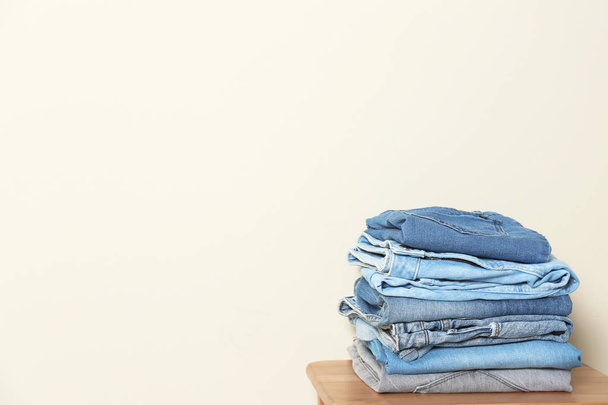Stack of different jeans on table against light background. Space for text - Photo, Image