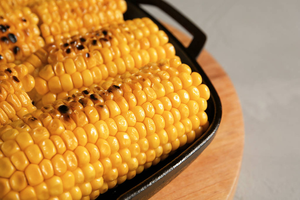 Fresh grilled tasty corn cobs in pan on light background, closeup - Photo, Image