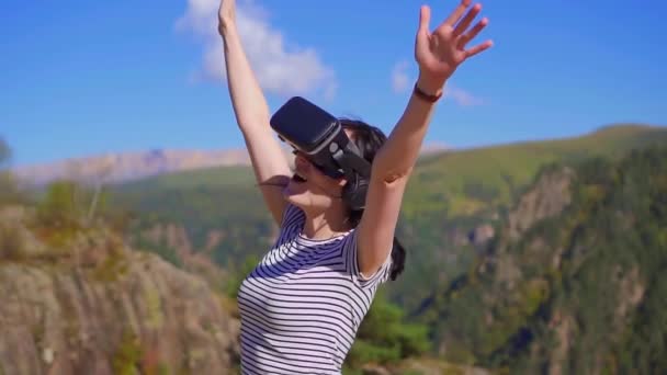 Girl in VR glasses in the mountains rejoices,slow mo - Кадри, відео
