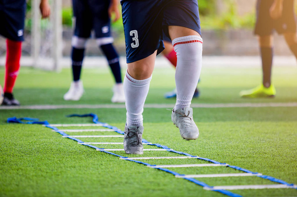 Soccer player Jogging and jump between marker for football training. Ladder Drills Exercises for Football Soccer team. Young player exercises on ladder drills. - Photo, Image