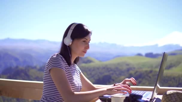 Dívka blogger psaní na notebooku na pozadí hor - Záběry, video
