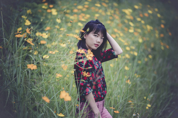 portrait of asian younger woman model pose in yellow flower blooming field - Photo, Image