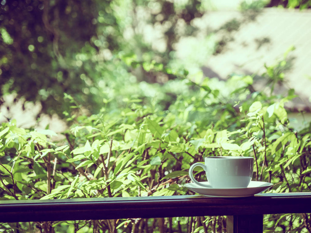 Terras met zicht op prachtige natuur en witte koffiekopje voor ontspannen - Foto, afbeelding